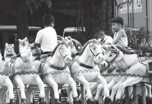  ??  ?? EAGER to ride, children hop on the horses, which will be part of the free carousel ride at Rizal Park for the Pasko Fiesta event, which is set to open on Nov. 22. BING GONZALES