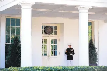  ?? CHIP SOMODEVILL­A GETTY IMAGES ?? A Marine stands watch outside the doors of the White House West Wing on Wednesday after President Donald Trump’s return to the Oval Office for the first time since his hospitaliz­ation for COVID-19.