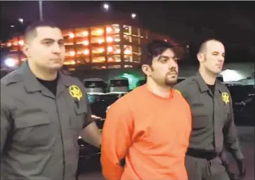  ?? Orange County Sheriff’s Department ?? DEPUTIES escort Hossein Nayeri back to the Orange County jail, from which he had escaped nine days earlier. Nayeri could face life in prison if convicted on charges of kidnapping, aggravated mayhem and torture.