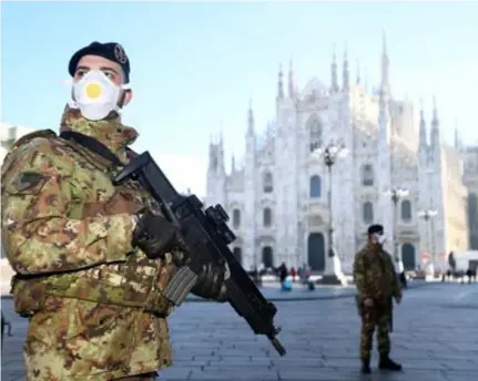  ?? FOTO REUTERS ?? In Milaan staan gemondmask­erde paracomman­do’s op het Piazza del Duomo.