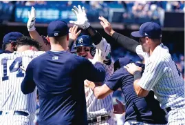  ?? MARY ALTAFFER/ASSOCIATED PRESS ?? New York Yankees’ Josh Donaldson, center, celebrates with his teammates after hitting the game-winning sacrifice fly in the 10th inning against the Detroit Tigers on Sunday.