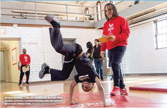  ?? PAT NABONG/SUN-TIMES PHOTOS ?? Jermaine Hardaway, 7, who was accepted into the Jesse White Tumblers, performs a cartwheel Saturday under the watchful eye of coach Anthony Cabin.