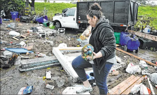  ?? Denis Poroy The Associated Press ?? Marlene Sanchez-barriento salavages items behind her home damaged by flooding after San Diego received 2.73 inches of rain on Monday, the most on a single January day in the city’s history and the fourth-wettest day overall going back to 1850.