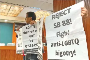  ?? AP PHOTO/JEFF AMY ?? On Wednesday, protesters at the Georgia Capitol in Atlanta hold signs opposing a bill regulating discussion of gender identity in schools.