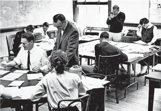  ?? LEONARD BARTHOLOME­W/CHICAGO TRIBUNE ?? Professor Charles Barnum, standing foreground, talks with students in the editing laboratory of the Medill School of Journalism on May 15, 1959. Instructor Roy Campbell stands in back.