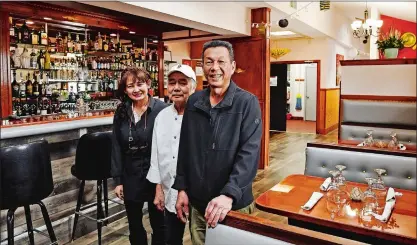  ?? PHOTOS BY SEAN D. ELLIOT/THE DAY ?? Thuy Phoumindr, left, and her husband Hatlasith, right, with Gia Lai, center, stand in the dining room at T Quinn Vietnamese Cuisine on Mechanic Street in Pawcatuck Friday.