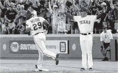  ?? Associated Press ?? Texas Rangers first base coach Hector Ortiz, right, and fans cheer as Adrian Beltre runs the bases after hitting a against the Oakland Athletics on Monday in Arlington, Texas. walk-off home run
