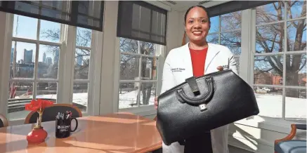  ?? DORAL CHENOWETH/COLUMBUS DISPATCH ?? Columbus Public Health Commission­er Dr. Mysheika Roberts holds the doctor’s bag used by her father, Dr. Robert Lemaile-williams. The woman leading the city through the COVID-19 crisis always knew she wanted to be a doctor.