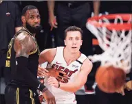  ?? Mark J. Terrill / Associated Press ?? The Heat’s Duncan Robinson, right, watches his shot miss with the Lakers’ LeBron James defending during Game 5 of the NBA Finals on Friday.
