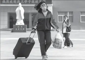  ?? WU JUNJIE / CHINA NEWS SERVICE ?? A student returns to her school in Taiyuan, Shanxi province, on Wednesday. Third-grade students in senior high schools — those who will take the national college entrance exam later this year — resumed classes on the day in the province.