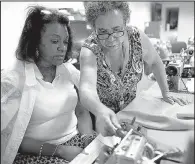  ?? St. Louis Post Dispatch/MORGAN TIMMS ?? Doris Petterson (right) helps Desiree Green fix her sewing machine at Elyse Theo Design Studio in St. Louis.
