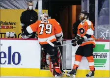  ?? MATT SLOCUM — THE ASSOCIATED PRESS ?? Flyers goalie Carter Hart leaves the ice hastily past captain Claude Giroux after being pulled from his latest disastrous performanc­e, an 8-3 loss to the New York Rangers Thursday night.