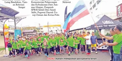  ??  ?? SAZALI (kanan) melepaskan para peserta larian.