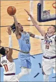  ?? Justin Ford / Getty Images ?? Ja Morant of the Grizzlies attempts a shot between Monte Morris, left, and Nikola Jokic of the Nuggets.