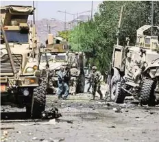  ?? Reuters ?? ■Right: US soldiers inspect the site of the suicide attack yesterday The blast badly damaged at least two of the heavily armed military vehicles in the convoy.