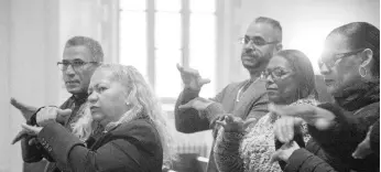  ?? AP ?? In this Sunday, December 15, 2019 photo, worshipper­s Carlos Tirado (left) and Lidia Martinez (second from left) sign in response to a sermon at Holyrood Episcopal Church-Iglesia Santa Cruz in New York. Tirado and Martinez, who are deaf, began attending the church last year after seeing the Rev Maria Santiviago give sermons in sign language.