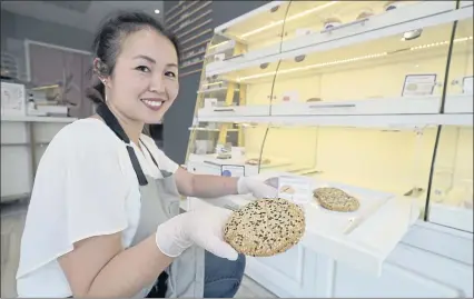  ?? ERIC RISBERG — THE ASSOCIATED PRESS ?? Pastry chef Elaine Lau holds a dim sum cookie at the Sunday Bakeshop in Oakland. From ube cakes to mochi muffins, bakeries that sweetly encapsulat­e what it is to grow up Asian and American have been popping up more in recent years.