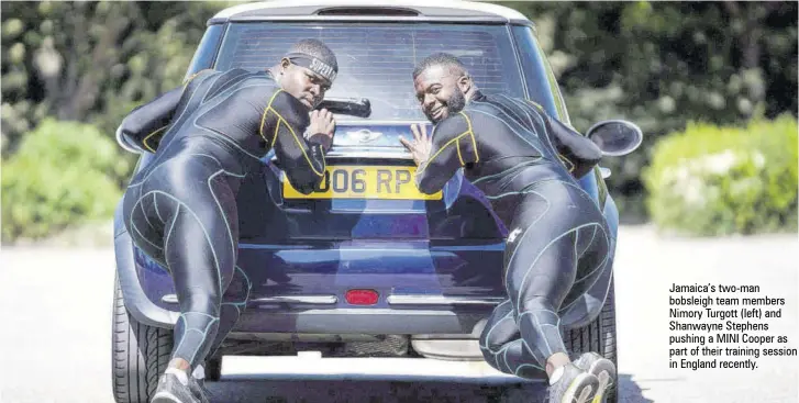  ??  ?? Jamaica’s two-man bobsleigh team members Nimory Turgott (left) and Shanwayne Stephens pushing a MINI Cooper as part of their training session in England recently.