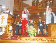  ?? DAVE MATHIESON/AMHERST NEWS ?? John Backa, left, and Edna Wilson read the names of the 75 coal miners killed in the 1958 Springhill mine disaster while Clare Canning rings a hand bell in memory during a hymn sing and memorial at St. Andrew’s-Wesley United Church in Springhill on Oct. 23, which marked the 60th anniversar­y of the disaster. All three lost their fathers in the disaster.