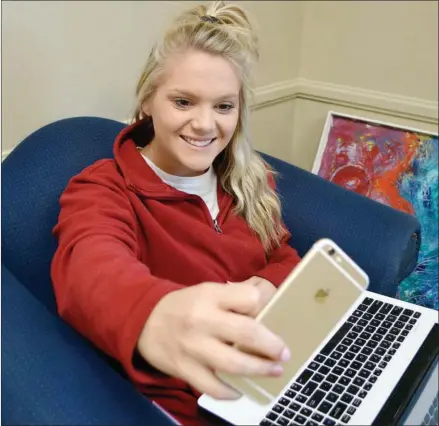  ?? TAMMY KEITH/RIVER VALLEY & OZARK EDITION ?? Lindsey Agerton of Vilonia, a junior at the University of Central Arkansas in Conway, takes a selfie between classes. Agerton said she didn’t realize the UCA yearbook, The Scroll, accepted selfies from students to use in its portrait section. The...