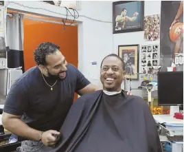  ?? AP PHOTO ?? ‘FRIENDLY ENVIRONMEN­T’: Barber Eric Muhammad, owner of A New You Barbershop, left, jokes with regular customer Marc M. Sims before measuring his blood pressure in Inglewood, Calif.