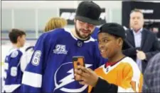  ?? DIRK SHADD — THE TAMPA BAY TIMES VIA AP ?? The Lightning’s Nikita Kucherov checks out a selfie he posed for with Jaydon Jones, 12, from Pennsauken, N.J., as Kucherov and fellow Lightning NHL All-Stars meet with youth hockey players Friday in Brandon, Fla.