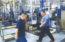  ?? ASSOCIATED PRESS FILE PHOTO ?? Workers pass industrial machines at Lord Corp. in Erie, Pa., on Oct. 24. Lord Corp. is a manufactur­er of industrial coatings, adhesives and sensing equipment for a range of commercial markets, including U.S. military contracts. After reviewing Labor...