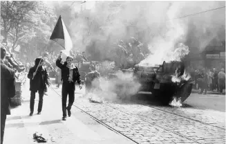  ??  ?? A la dcha., unos manifestan­tes checoslova­cos ondean la bandera de su país durante la invasión de 1968.