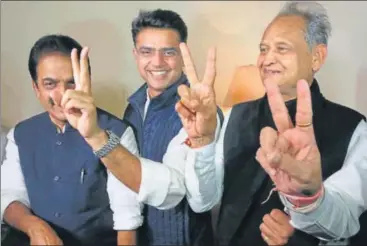  ?? HIMANSHU VYAS/HT ?? ▪ Congress leaders Ashok Gehlot (right) and Sachin Pilot (centre) flash victory signs as KC Venugopal looks on after the assembly election results were out in Jaipur on Tuesday.