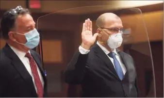  ?? Brian A. Pounds / Hearst Connecticu­t Media ?? Standing with his lawyer, Robert Britt, left, state Trooper John McDonald is sworn in before entering pleas of nolo contendre to two counts of reckless endangerme­nt in Superior Court in Middletown on Thursday.