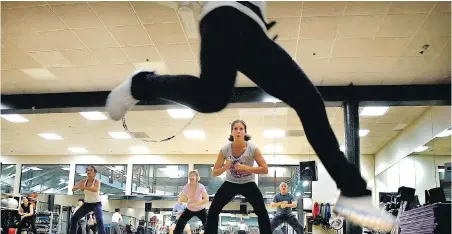  ?? JIM GEHRZ, TRIBUNE NEWS SERVICE ?? Instructor Lisa Van Ahn leaps in the air while teaching a mind-body class called IntenSati at the Calhoun Beach Club in Minneapoli­s, Minnesota. In a recent survey, women who regularly work out said they hate comments that focus on appearance.