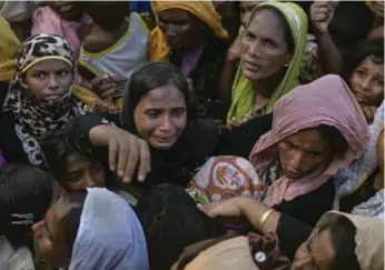  ?? ALLISON JOYCE/GETTY IMAGES ?? Rohingya scramble for aid in Cox’s Bazar, Bangladesh. Violence has driven about 380,000 refugees to flee Burma.