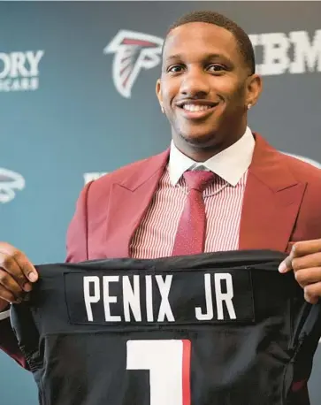  ?? JOHN BAZEMORE/AP ?? Falcons first round draft choice quarterbac­k Michael Penix Jr., holds a Falcons jersey during a news conference on Friday in Flowery Branch, Ga.