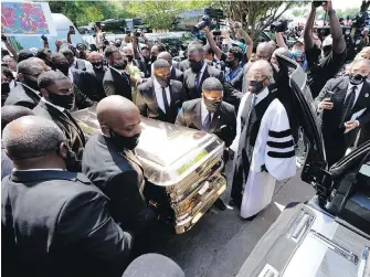  ??  ?? Mourners push the casket of George Floyd into a hearse as the Rev. Al Sharpton, right, looks on after the funeral service for Floyd at the Fountain of Praise church Tuesday in Houston.