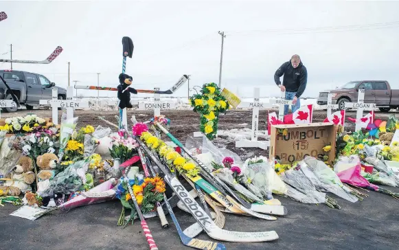  ?? BRANDON HARDER ?? Rocky Salisbury of Nipawin sets up crosses at the intersecti­on of highways 35 and 335, where the Humboldt Broncos’ bus crashed on April 6.