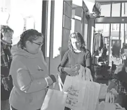  ??  ?? Waxwing owner Steph Davies hands out swag bags to customers Saturday.