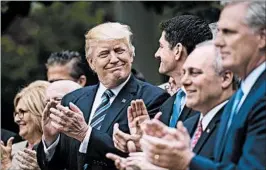  ?? JABIN BOTSFORD/WASHINGTON POST ?? President Donald Trump and House members applaud their health care bill Thursday.