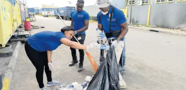  ??  ?? Kingston Wharves Limited (KWL) team members pick up trash to clean up sections of the Newport West community, separating the recyclable material from the rest of the garbage. The exercise was organised by the KWL Millennial Club.