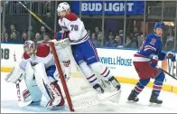  ?? MARY ALTAFFER / AP ?? Montreal Canadiens defenseman Andrei Markov flies onto the net and goalie Carey Price after being checked by New York Rangers center JT Miller during Game 6 of their Stanley Cup playoff series on Saturday in New York.