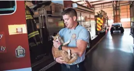  ?? JOSH MORGAN/GREENVILLE NEWS ?? Jordan Lide holds Flame at Belmont Fire Station.