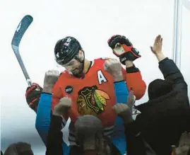  ?? MATT MARTON/AP ?? Blackhawks defenseman Seth Jones celebrates with fans after scoring during overtime against the Islanders on Friday.