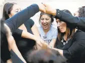  ??  ?? Ingrid Ramirez, 17, from left, Isabel Lopez, 18, and Director of Developmen­t Jaime Woods participat­e in a human knot exercise during a Teen Success workshop.