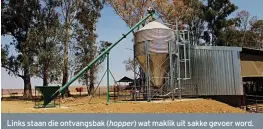  ??  ?? Links staan die ontvangsba­k (hopper) wat maklik uit sakke gevoer word. ’n Awegaar voer dit dan na die silo. Dié stelsel word een keer per week gevul en lewer outomaties voer aan die lamhokke met die minimum vermorsing en moeite.