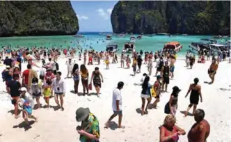  ??  ?? A crowd of tourists on the Maya Bay beach, on the southern Thai island of Koh Phi Phi.