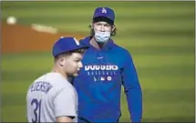  ?? Ross D. Franklin Associated Press ?? CLAYTON KERSHAW leaves the field with Joc Pederson after a win. New rules mandate masks except while playing.