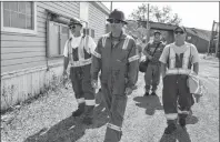  ?? SHARON MONTGOMERY-DUPE/CAPE BRETON POST ?? Employees of Savage CANAC Corp. in Sydney including, in front from left, Mel Windsor of Sydney, an electrical technician; Gary Chordis of Donkin, operator; and Ricky Pastuck of River Ryan, an electrical technician, walk with other workers onto the grounds of the Internatio­nal Coal Pier in Sydney on Monday morning.