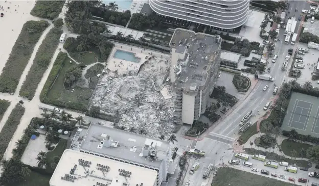  ??  ?? Search and rescue personnel work in the rubble of the 12-storey condo tower that crumbled to the ground after a partial collapse of the building