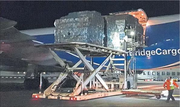  ??  ?? The precious cargo of face masks and other vital equipment to help hospitals across Scotland fight the Covid-19 pandemic is offloaded on to the tarmac at Prestwick Airport yesterday. The supplies will be delivered to hospitals and care homes over the next few days