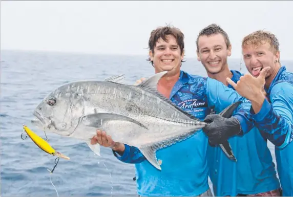  ??  ?? Simon Bochow, Andy Steele and Taylor Kupr with a trevally, caught out wide with Arafura Bluewater Charters