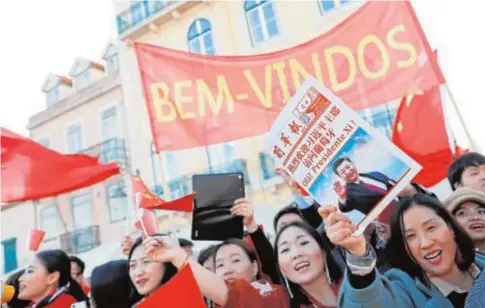  ?? REUTERS ?? Un grupo de jóvenes saluda a la comitiva de Xi Jinping a su paso por las calles de Lisboa